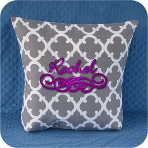 Puede incluir: Almohada con estampado gris y blanco con el nombre "Rachel" bordado en morado.