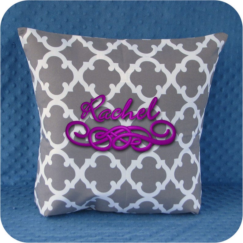 Puede incluir: Almohada con estampado gris y blanco con el nombre "Rachel" bordado en morado.