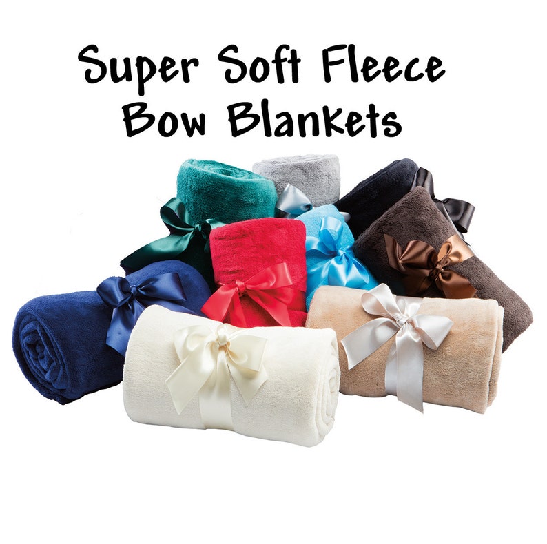 A graphic showing the colors of the super soft fleece blankets we offer:  vanilla, tan, blue, brown, black, and gray.  All come with a matching decorative satin ribbon with hook & loop closure for easy gifting and/or quick storage.  This fleece throw makes a great gift.