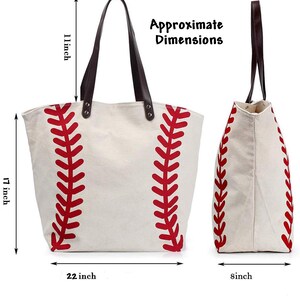May include: A cream-colored canvas tote bag with a red baseball stitch pattern, dark brown leather straps, and metal rivets. The bag measures 17 inches in height, 22 inches in width, and 8 inches in depth, with an 11-inch strap drop height.