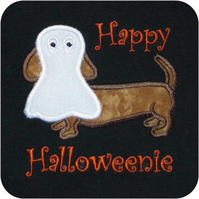 May include: A brown and white dachshund wearing a white ghost costume. The text "Happy Halloweenie" is embroidered in orange on a black background.