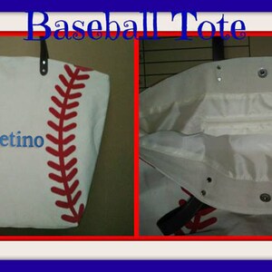 A large off white canvas tote bag with printed red baseball stitching and the monogram name 'Ebetino' in blue thread. The bag is shown open to reveal the white lining, inner zippered pocket and black faux leather straps.