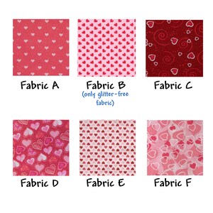 May include: Six fabric swatches with different heart patterns. The fabrics are pink, red, and white with glitter. The fabrics are labeled A through F. Fabric B is labeled as "only glitter-free fabric".
