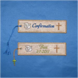 May include: Two embroidered bookmarks with a dove and cross design. The top bookmark reads "Confirmation" in blue script. The bottom bookmark has the name "Ben" and the date "3-7-2013" in green script. Both have a tassel.