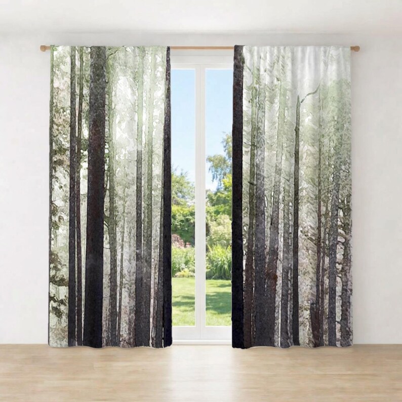 a pair of curtains with a forest scene printed on them, hanging in front of a window.