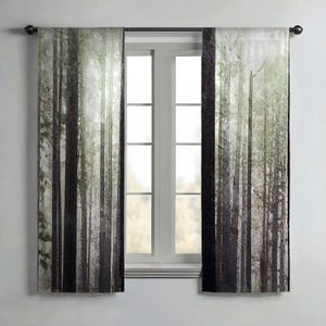 a window with a curtain that has a forest scene printed on it.