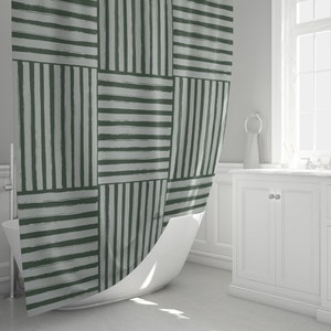 May include: A green and white striped shower curtain with a geometric pattern. The curtain is made of fabric and has a textured look.