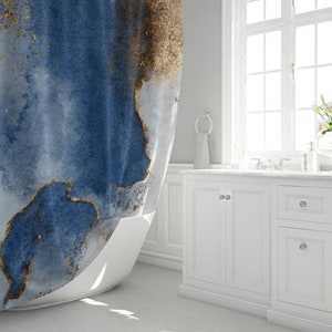 May include: A blue and gold abstract watercolor shower curtain with a white bathtub in the foreground.