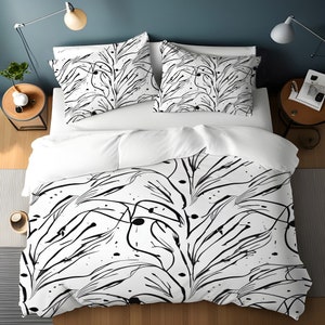 May include: White and black bedding set with a duvet cover featuring a black and white abstract floral pattern. The duvet cover has a modern, minimalist design with thin black lines and small black dots.