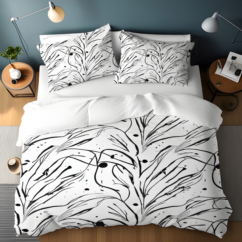 May include: White and black bedding set with a duvet cover featuring a black and white abstract floral pattern. The duvet cover has a modern, minimalist design with thin black lines and small black dots.