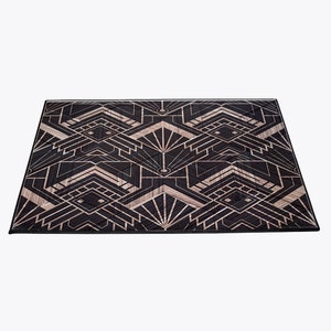 May include: A black and gold geometric patterned rug with an Art Deco design.