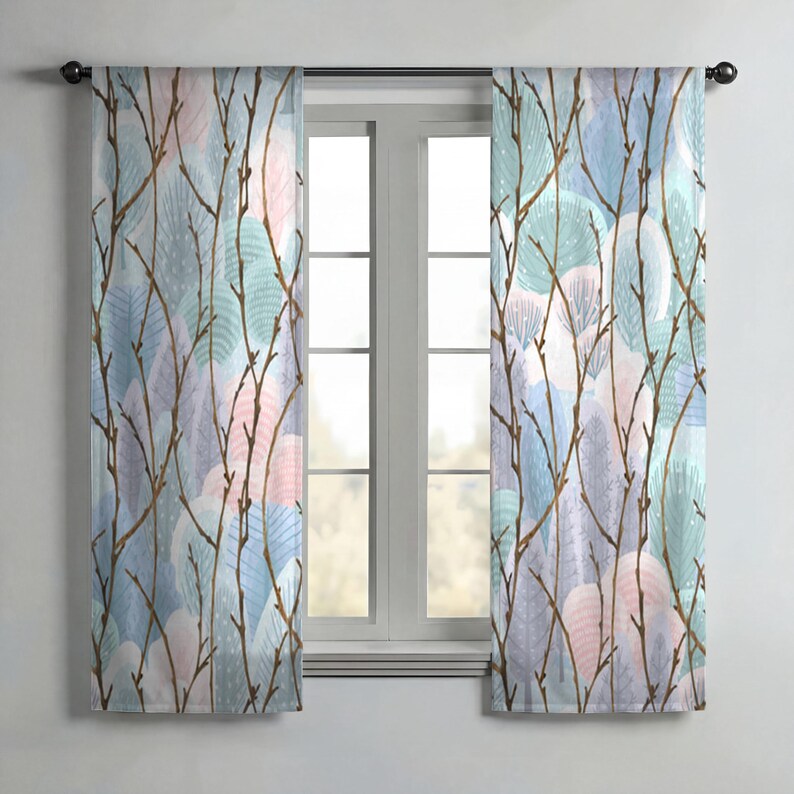 a pair of curtains with a leafy branch pattern, hanging in front of a window.