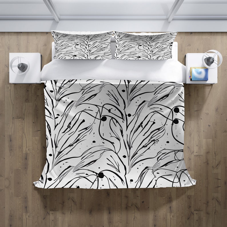 May include: Black and white bedding set featuring an abstract pattern of lines and dots. The set includes a duvet cover and two pillowcases.