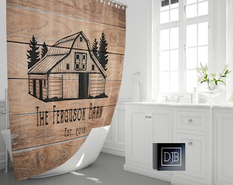 May include: A brown wooden shower curtain with a black and white illustration of a barn with trees on either side. The text "The Ferguson Barn Est. 2018" is printed below the barn.