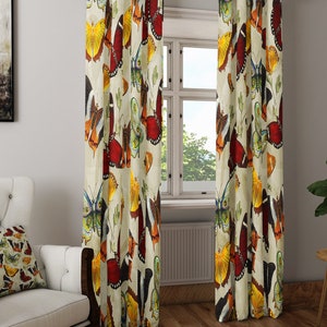 May include: A pair of cream-colored curtains with a colorful butterfly pattern. The butterflies are in shades of red, orange, yellow, green, and blue.