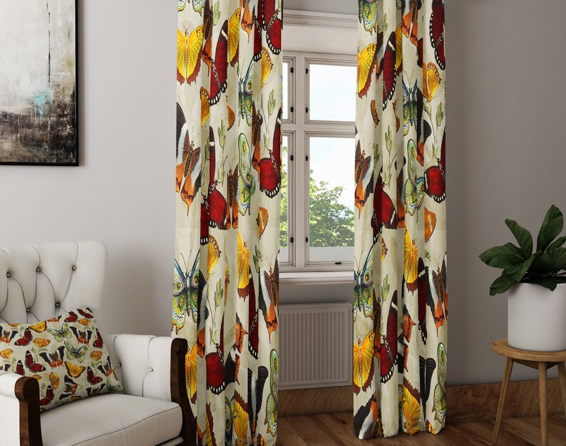 May include: A pair of cream-colored curtains with a colorful butterfly pattern. The butterflies are in shades of red, orange, yellow, green, and blue.