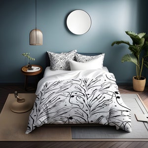 May include: White duvet cover featuring a black and white abstract floral design. The duvet cover is on a bed with white pillows against a blue wall.