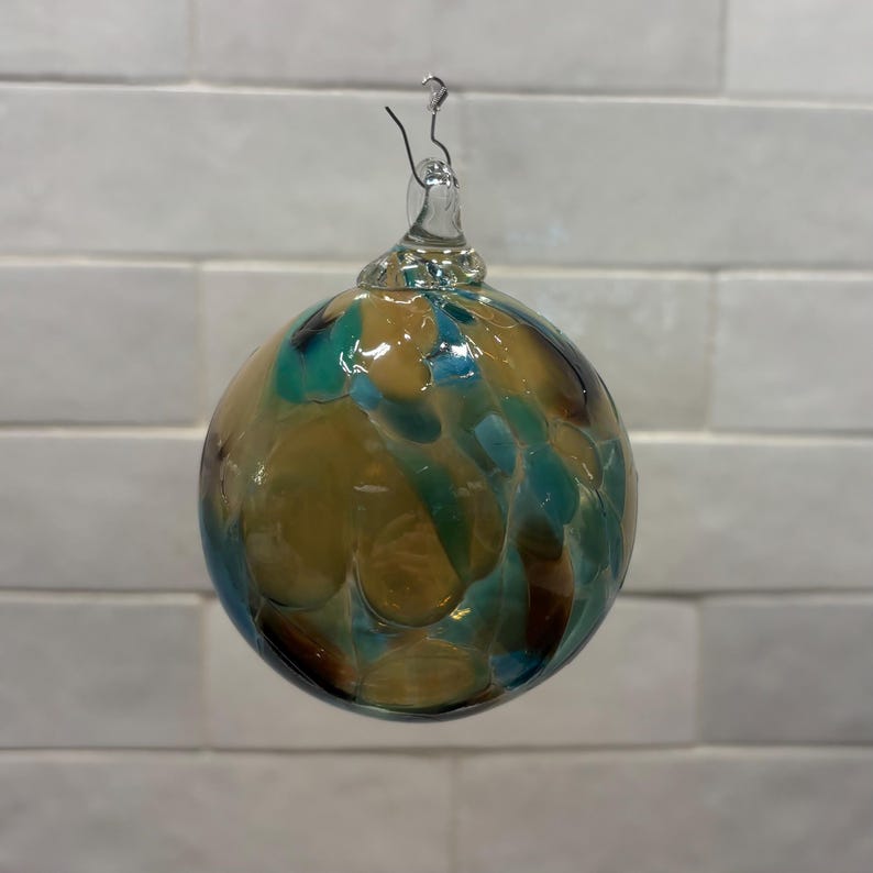 Adorno navideño de vidrio soplado a mano, en beige, marrón, verde azulado y crema. Hecho a mano en las montañas Ozark. Nuevo color para 2026. Nombre del color: Adoquín. imagen 2