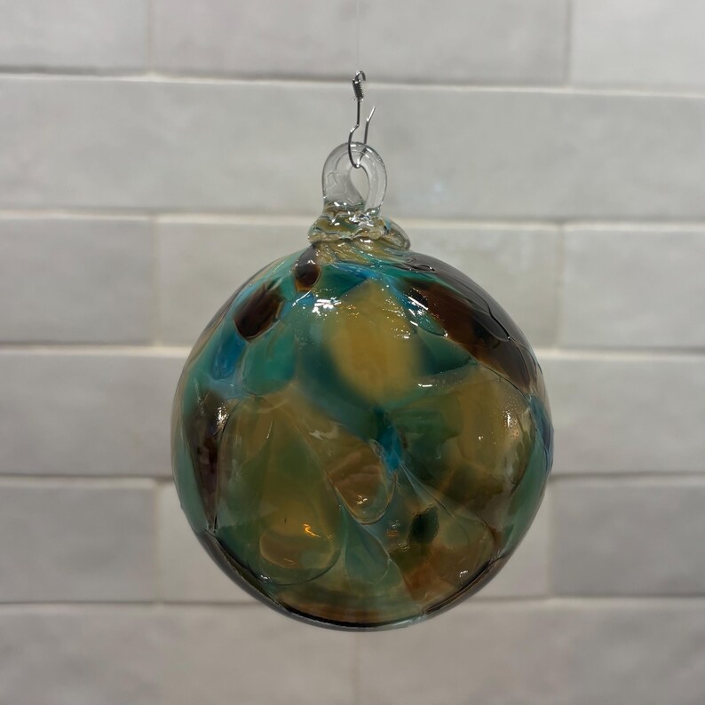Adorno navideño de vidrio soplado a mano, en beige, marrón, verde azulado y crema. Hecho a mano en las montañas Ozark. Nuevo color para 2026. Nombre del color: Adoquín. imagen 3