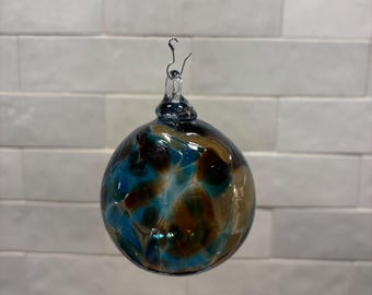 Adorno navideño de vidrio soplado a mano, marrón, verde azulado y gris pardo, fabricado en las montañas Ozark. Nuevo color para 2026. Nombre del color: River Rock.