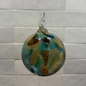 Adorno navideño de vidrio soplado a mano, en beige, marrón, verde azulado y crema. Hecho a mano en las montañas Ozark. Nuevo color para 2026. Nombre del color: Adoquín. imagen 4