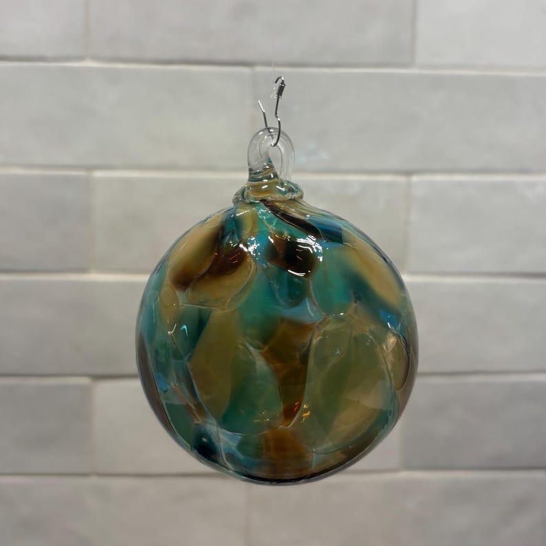 Adorno navideño de vidrio soplado a mano, en beige, marrón, verde azulado y crema. Hecho a mano en las montañas Ozark. Nuevo color para 2026. Nombre del color: Adoquín. imagen 4
