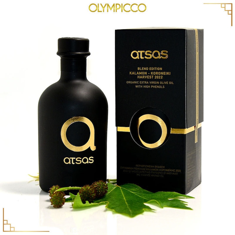 K&ouml;nnte beinhalten: Ein schwarzes Oliven&ouml;lflaschen- und Box-Set mit goldfarbenen Buchstaben und Akzenten. Die Flasche und die Box tragen den Markennamen "atsas" und den Text "BLEND EDITION KALAMON-KORONEIKI HARVEST 2022 ORGANIC EXTRA VIRGIN OLIVE OIL WITH HIGH PHENOLS."