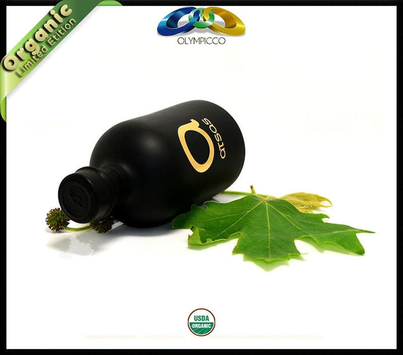 K&ouml;nnte beinhalten: Eine schwarze Oliven&ouml;lflasche mit goldfarbenen Buchstaben und einem gr&uuml;nen Blatt. Die Flasche ist mit "OTSOS" und "Organic Limited Edition" beschriftet. Das Bild enth&auml;lt auch das USDA Organic-Siegel.