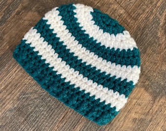 May include: A green and white striped crocheted beanie hat.