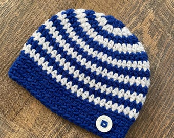 May include: Blue and white striped crocheted beanie with a blue button.