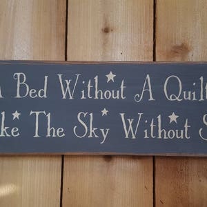 A Bed Without A Quilt Is Like The Sky Without Stars distressed wooden sign