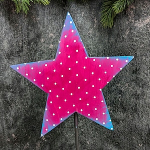 Può includere: Una stella di legno rosa con pois bianchi e bordo blu. La stella è montata su un'asta di metallo nero. Articolo decorativo per la casa o il giardino. Decorazione festosa.