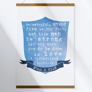 May include: A blue watercolor shield with a white background and the text "Be watchful, stand firm in the faith act like men be strong Let all that you do be done in love 1 Corinthians 16:13-14 NOAH & RYAN".