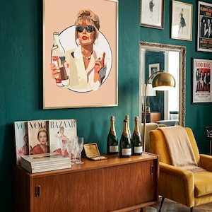 May include: A stylish interior scene featuring a framed print of a woman with a bottle, set against a teal wall. A wooden cabinet holds magazines and champagne bottles. A gold lamp and yellow armchair add to the decor. Additional framed art is visible.