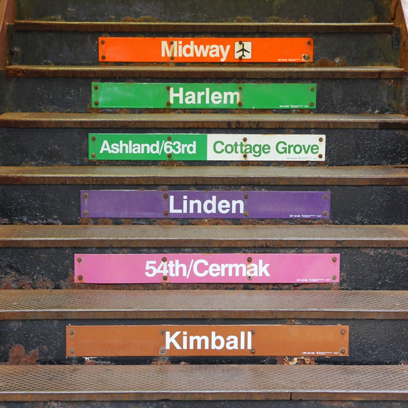 May include: A set of six subway station signs with different names and colors. The signs are attached to the steps of a subway station. The signs read: Midway, Harlem, Ashland/63rd Cottage Grove, Linden, 54th/Cermak, Kimball.