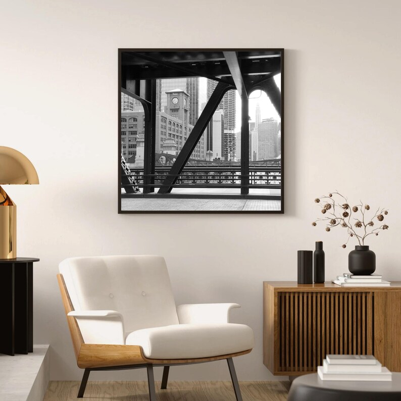 Puede incluir: Fotograf&iacute;a en blanco y negro de un horizonte urbano visto desde un puente. La estructura de acero del puente est&aacute; en primer plano, con los edificios en el fondo.