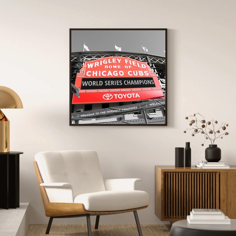 May include: A black and white photograph of Wrigley Field, home of the Chicago Cubs, with a red sign that reads "Wrigley Field, Home of Chicago Cubs, World Series Champions, Toyota".