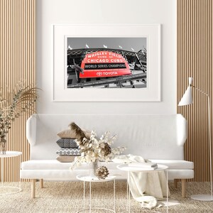 May include: A black and white photograph of Wrigley Field, home of the Chicago Cubs, with a red sign that reads "Wrigley Field, Home of the Chicago Cubs, World Series Champions, Toyota".