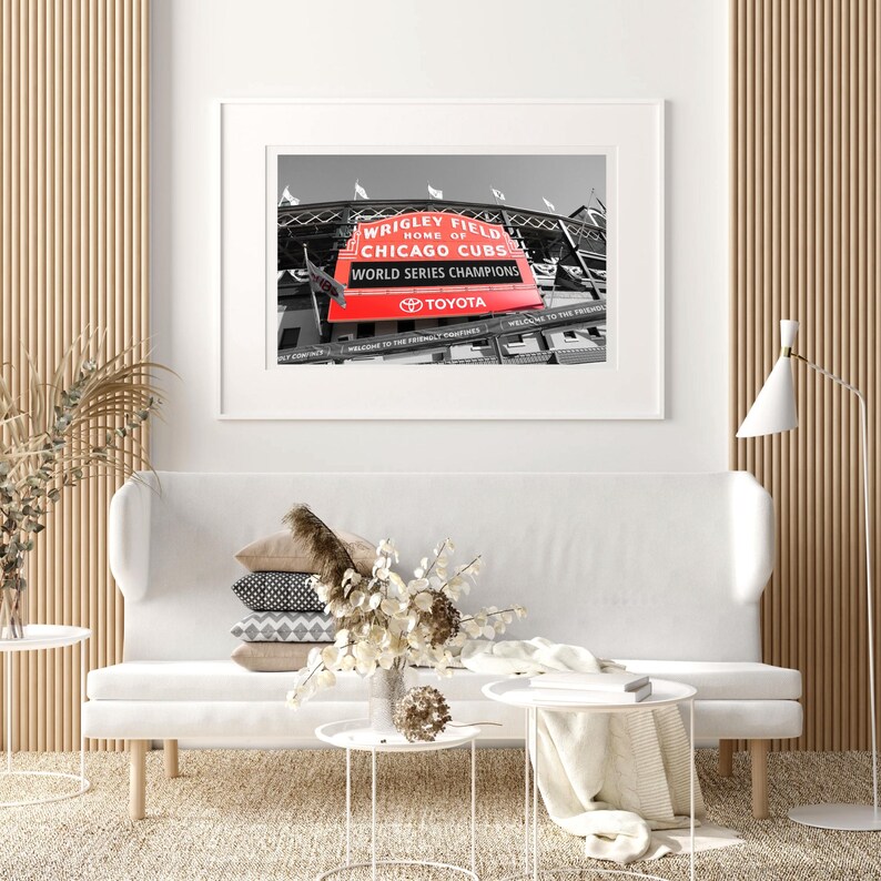 May include: A black and white photograph of Wrigley Field, home of the Chicago Cubs, with a red sign that reads "Wrigley Field, Home of the Chicago Cubs, World Series Champions, Toyota".