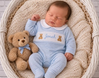 May include: A light blue and white striped long-sleeve footed sleeper with a white Peter Pan collar. The chest features a white panel embroidered with the name Jonah in blue script, flanked by two small brown teddy bear motifs, next to a plush bear.