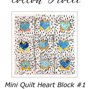 Peut inclure: Un mini bloc de cœur de courtepointe avec neuf carrés, chacun avec un motif de cœur. Les cœurs sont dans des tons de bleu et de sarcelle, sur un fond jaune, et entourés d'un tissu blanc à pois noirs. Le texte "Cotton Frolic" et "Mini Quilt Heart Block #1" sont également visibles.