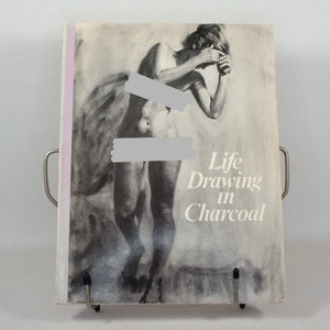 May include: A book titled "Life Drawing in Charcoal" featuring a black and white illustration of a nude figure on the cover.