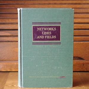 Puede incluir: Un libro de tapa dura verde titulado "Networks Lines and Fields" de John D. Ryder. El libro forma parte de la serie Prentice-Hall Electrical Engineering.