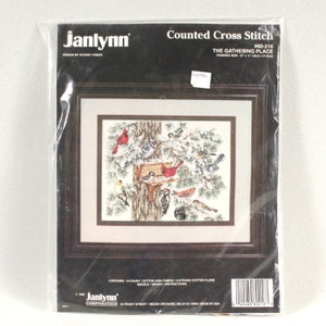 May include: Counted cross stitch pattern for a winter scene with birds and a bird feeder. The pattern is called "The Gathering Place" and is by Janlynn. The finished size is 36.6 x 27.5 cm.