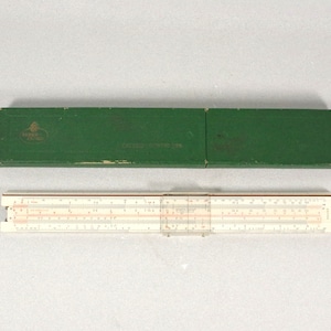 Może przedstawiać: Biała suwmiarka w zielonym etui. Etui ma nadrukowany tekst "Faber Castell" i "Made in Germany".