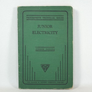 Könnte beinhalten: Ein grünes Buch mit dem Titel "Junior Electricity" aus der Reihe Progressive Technical Series von Gordon Darling. Das Buch wurde von The Clarke & Stuart Company Limited herausgegeben.