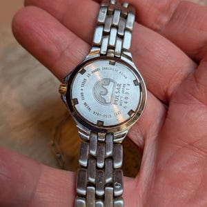 May include: A silver-toned Pulsar watch with a metal band. The watch face is visible, displaying the brand name and model information. The back of the watch reads "Water Resistant 10BAR ST. STEEL + BASE METAL V782-0510".