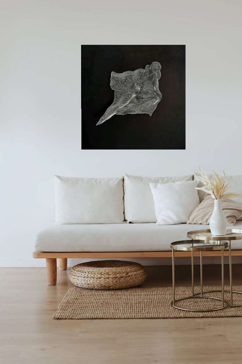 May include: Abstract art piece with a textured, flowing design in shades of silver and white against a black background. The artwork is mounted on a wall above a light-colored sofa, enhancing the room's modern aesthetic.