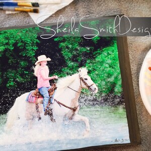 May include: A young girl in a pink shirt and a straw hat rides a white horse through a green forest. The horse is splashing water as it runs through the stream. The image is a painting on canvas.
