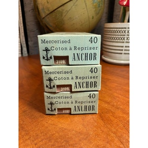 May include: Three boxes of Anchor mercerized cotton thread for embroidery. Each box is green and white with the text "Mercerised Coton à Repriser 40 ANCHOR 3109."